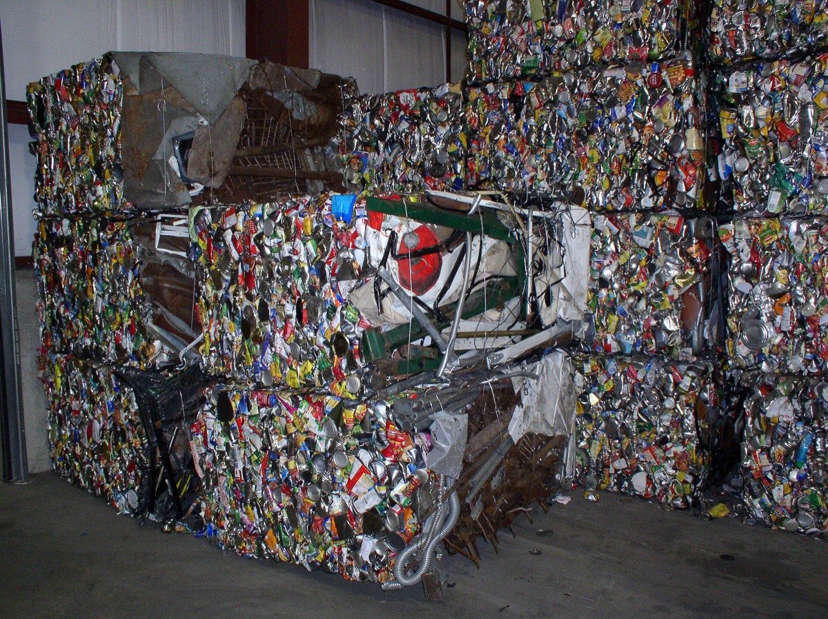 Bales of crushed beverage cans stacked at a recycling facility