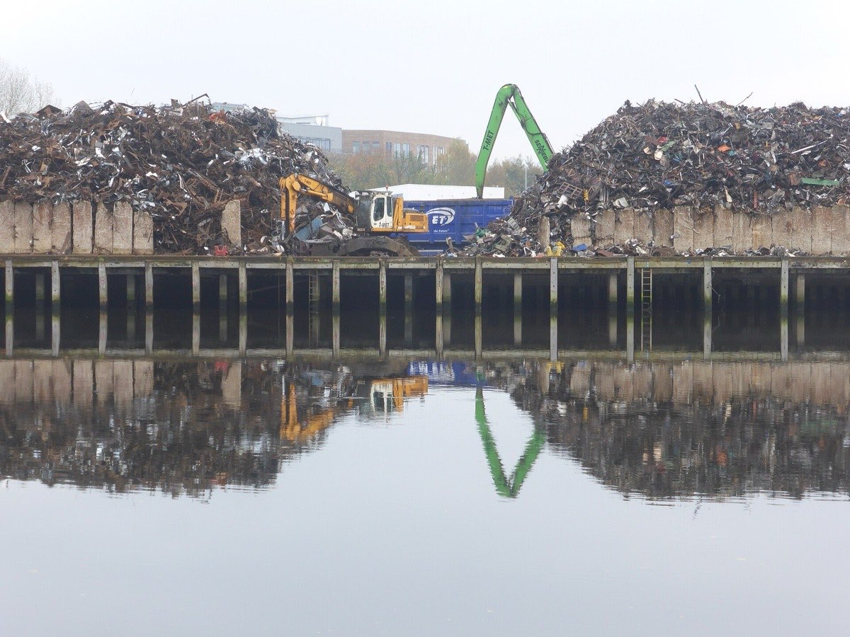 Scrap metal piles and a material handler at the recycling yard